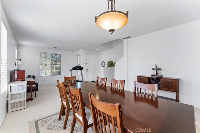 dining room with visible vents and light colored carpet