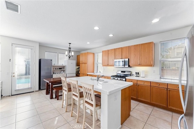 kitchen with light tile patterned floors, visible vents, appliances with stainless steel finishes, and a sink