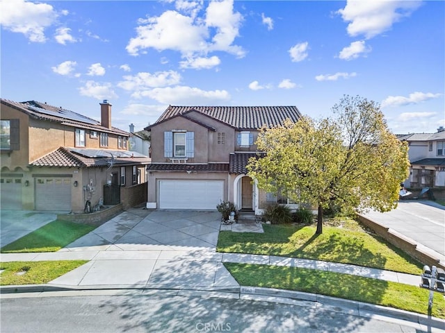 view of front of home featuring stucco siding, driveway, a tile roof, a front yard, and a garage