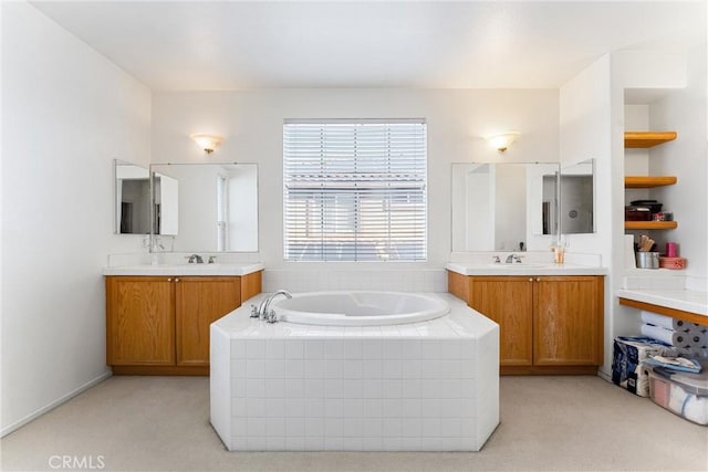 full bath featuring a sink, a garden tub, and two vanities