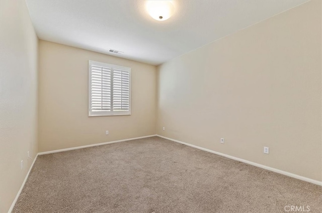 carpeted spare room featuring baseboards and visible vents