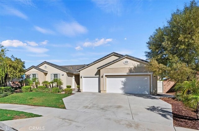 ranch-style home featuring an attached garage, driveway, and a front lawn