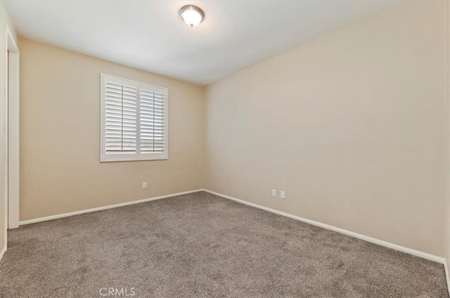 unfurnished room with carpet flooring and baseboards