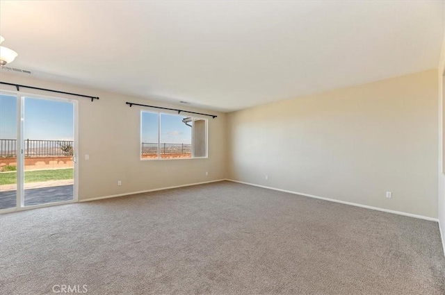 carpeted empty room featuring visible vents and baseboards