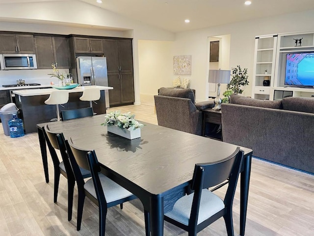 dining space featuring lofted ceiling, recessed lighting, and light wood-style floors