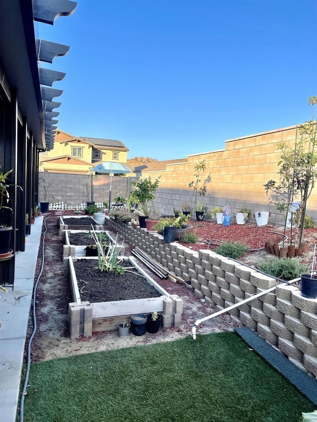 view of yard featuring fence and a garden