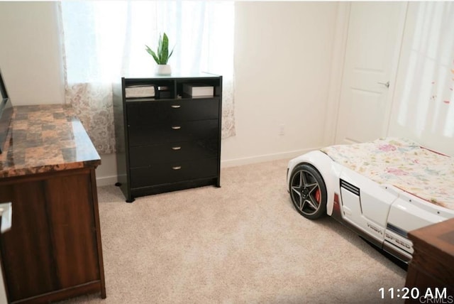 bedroom featuring baseboards and light colored carpet