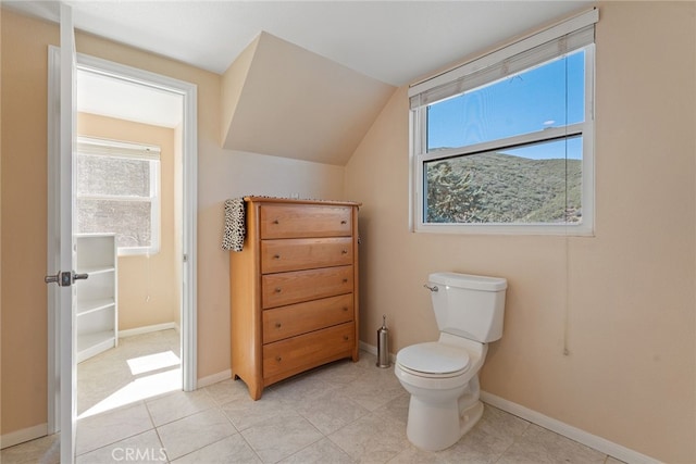 bathroom featuring tile patterned floors, toilet, lofted ceiling, and baseboards