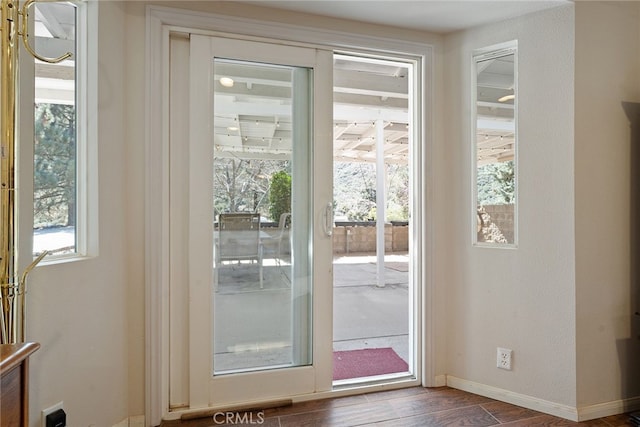 doorway with dark wood-style floors and baseboards