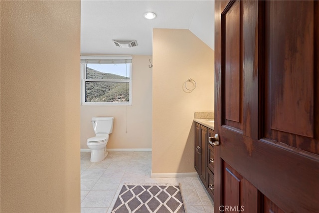 bathroom featuring vanity, baseboards, visible vents, tile patterned floors, and toilet