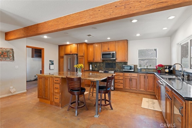 kitchen with a sink, appliances with stainless steel finishes, beamed ceiling, tasteful backsplash, and brown cabinets