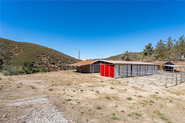 view of yard with an exterior structure, a mountain view, and an outdoor structure