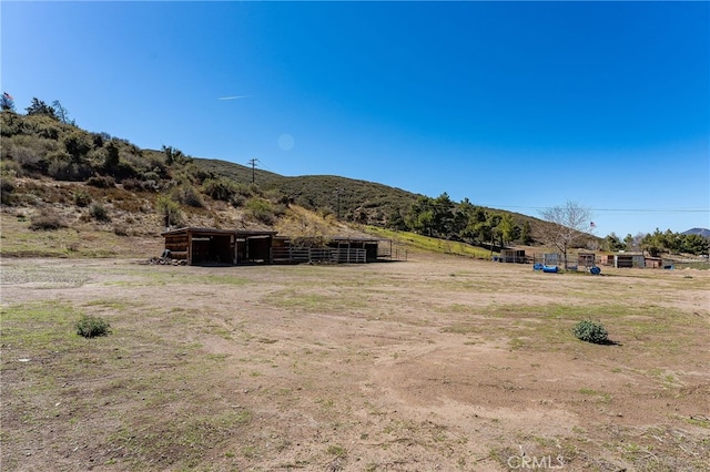 view of yard featuring a rural view and an outdoor structure