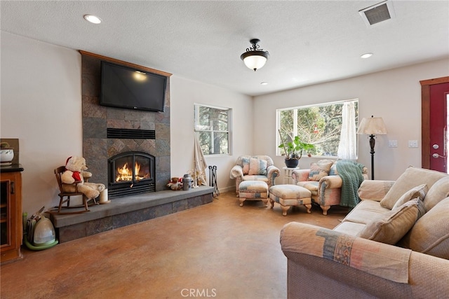 carpeted living area with a tiled fireplace, recessed lighting, visible vents, and a textured ceiling