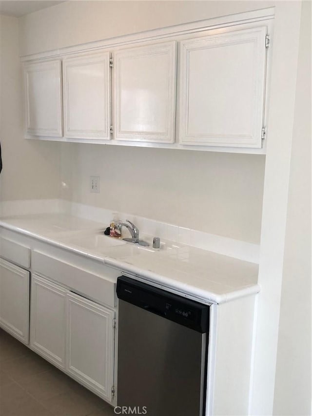 kitchen with dishwasher, light countertops, and white cabinetry