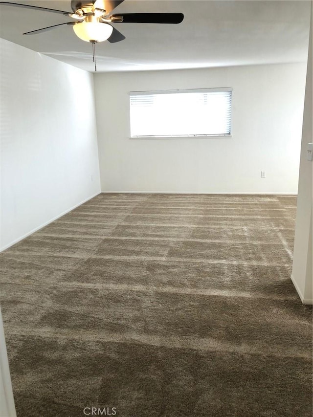 carpeted spare room with a ceiling fan