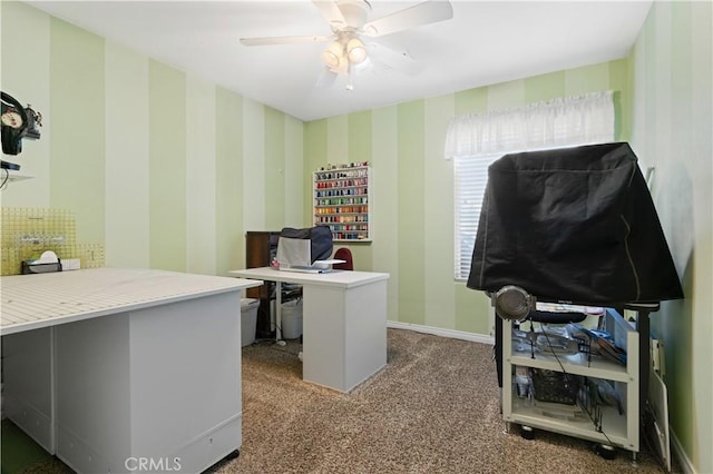 office area with wallpapered walls, ceiling fan, baseboards, and dark colored carpet