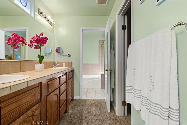 bathroom with double vanity, visible vents, a sink, and a bath