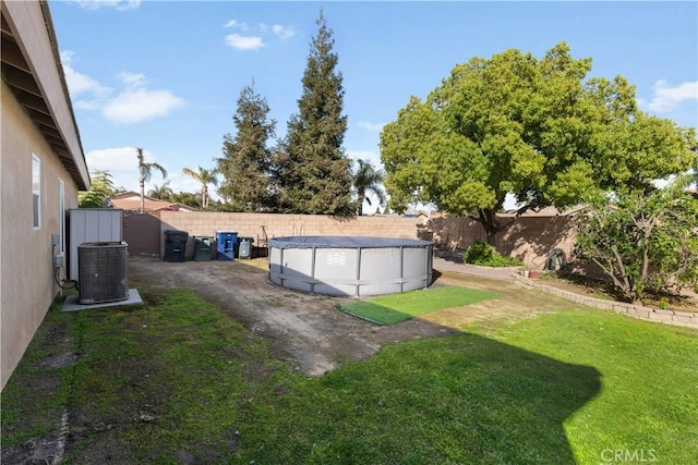 view of yard with a fenced in pool, a fenced backyard, and central AC unit