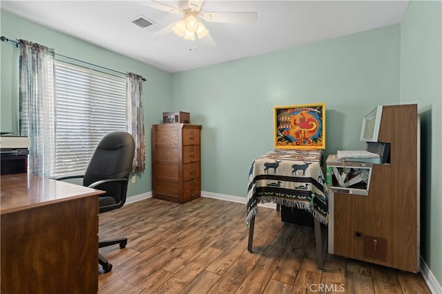 office area featuring ceiling fan, wood finished floors, visible vents, and baseboards