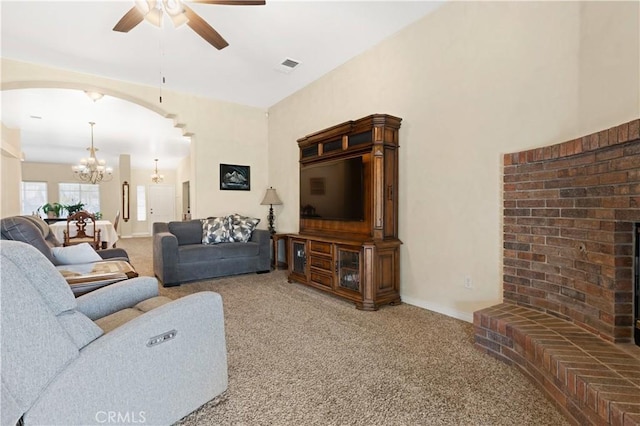 carpeted living room featuring arched walkways, ceiling fan with notable chandelier, visible vents, and baseboards