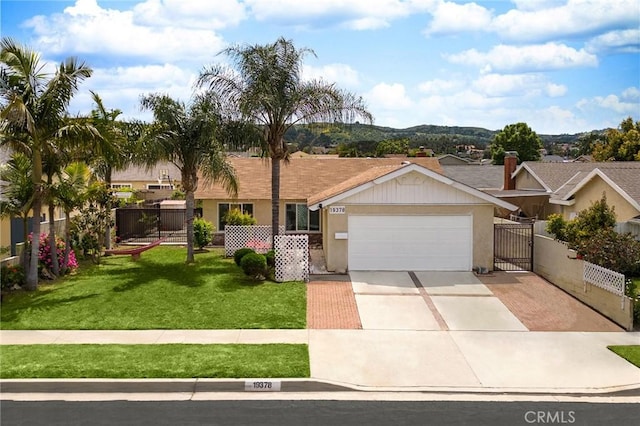 ranch-style house featuring concrete driveway, an attached garage, fence, a front lawn, and stucco siding