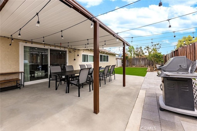 view of patio / terrace featuring a grill, fence, and outdoor dining area