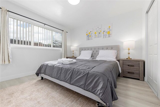 bedroom with wood finished floors and baseboards