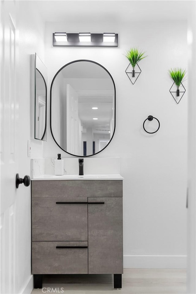 bathroom featuring vanity, baseboards, and wood finished floors