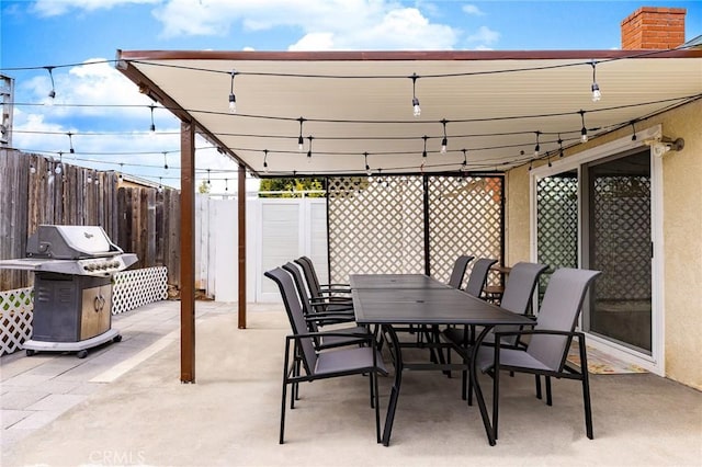 view of patio featuring outdoor dining area, area for grilling, and fence