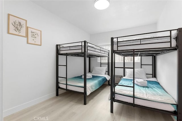 bedroom featuring wood finished floors and baseboards