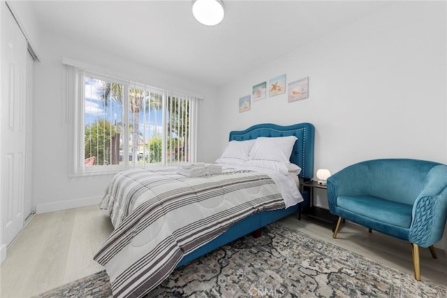 bedroom featuring a closet, baseboards, and wood finished floors