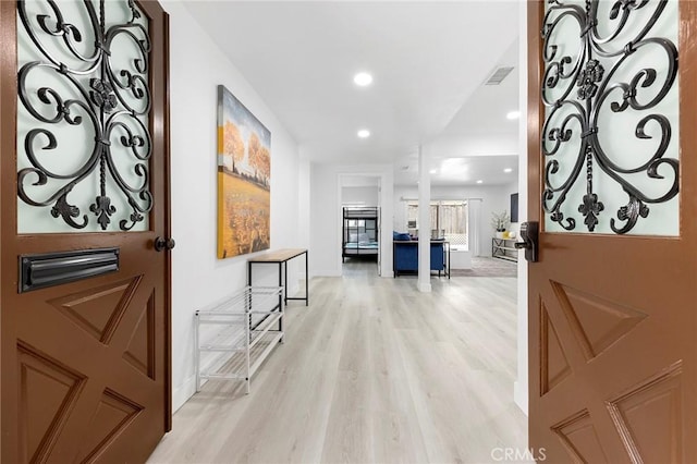 corridor featuring baseboards, recessed lighting, visible vents, and light wood-style floors