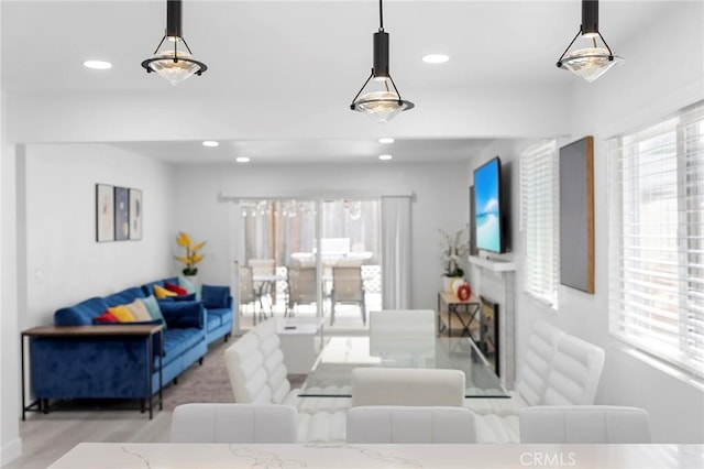 living room featuring a fireplace, wood finished floors, and recessed lighting