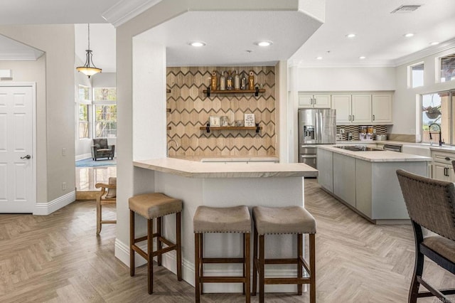 14797 Wild Colt Pl, Jamul, CA 91935 - kitchen featuring stainless steel fridge, a kitchen bar, crown molding, a sink, and healthy amount of natural light