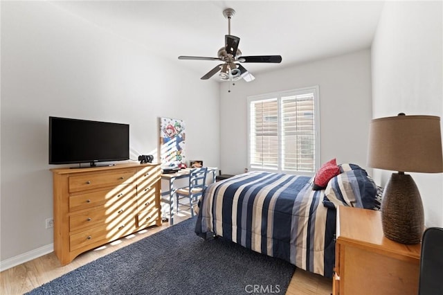 bedroom with a ceiling fan, light wood-style floors, and baseboards