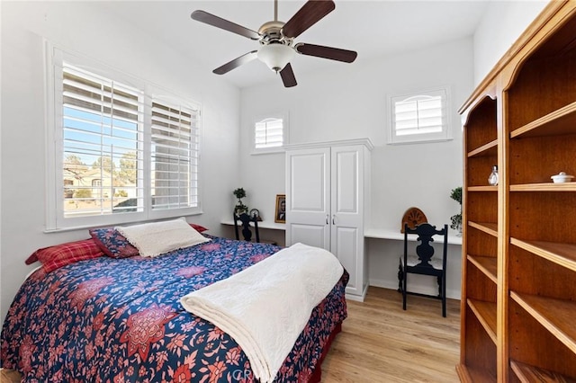 bedroom featuring multiple windows, a ceiling fan, and wood finished floors