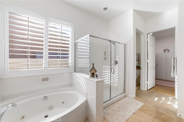 full bath featuring tile patterned floors, a jetted tub, and a shower stall