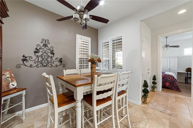 dining space with light tile patterned floors, a ceiling fan, and baseboards