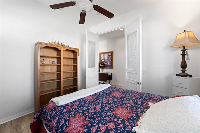 bedroom with baseboards, wood finished floors, and a ceiling fan