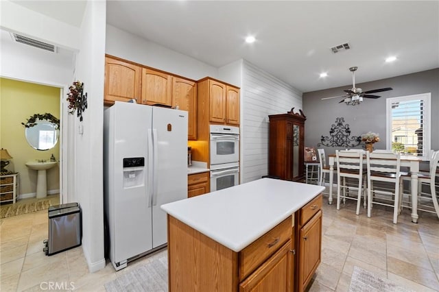 kitchen featuring a sink, visible vents, white appliances, and ceiling fan