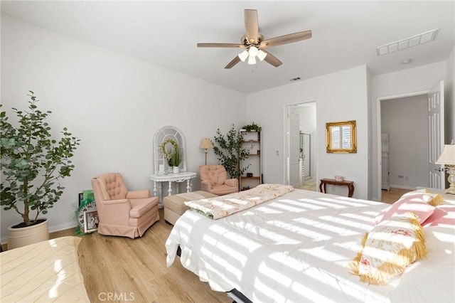 bedroom with a ceiling fan, baseboards, visible vents, and light wood-type flooring