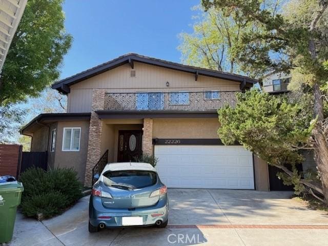 view of front facade featuring driveway, a garage, and stucco siding