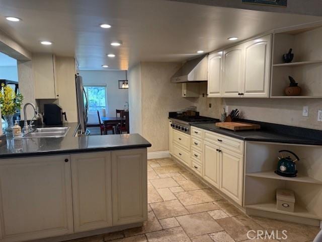 kitchen featuring a sink, wall chimney exhaust hood, open shelves, and stainless steel appliances