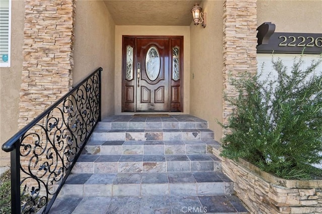 entrance to property featuring stucco siding