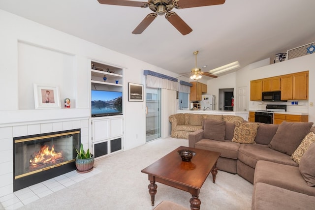 living area with built in shelves, light colored carpet, lofted ceiling, and a tiled fireplace