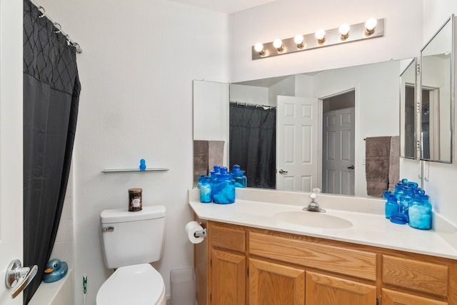 bathroom featuring toilet, vanity, and a shower with curtain