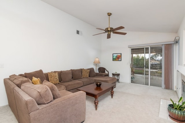 living area featuring visible vents, high vaulted ceiling, a fireplace, ceiling fan, and light colored carpet