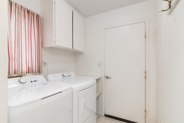 clothes washing area featuring cabinet space and washer and clothes dryer