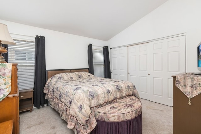 bedroom with vaulted ceiling, a closet, and light carpet